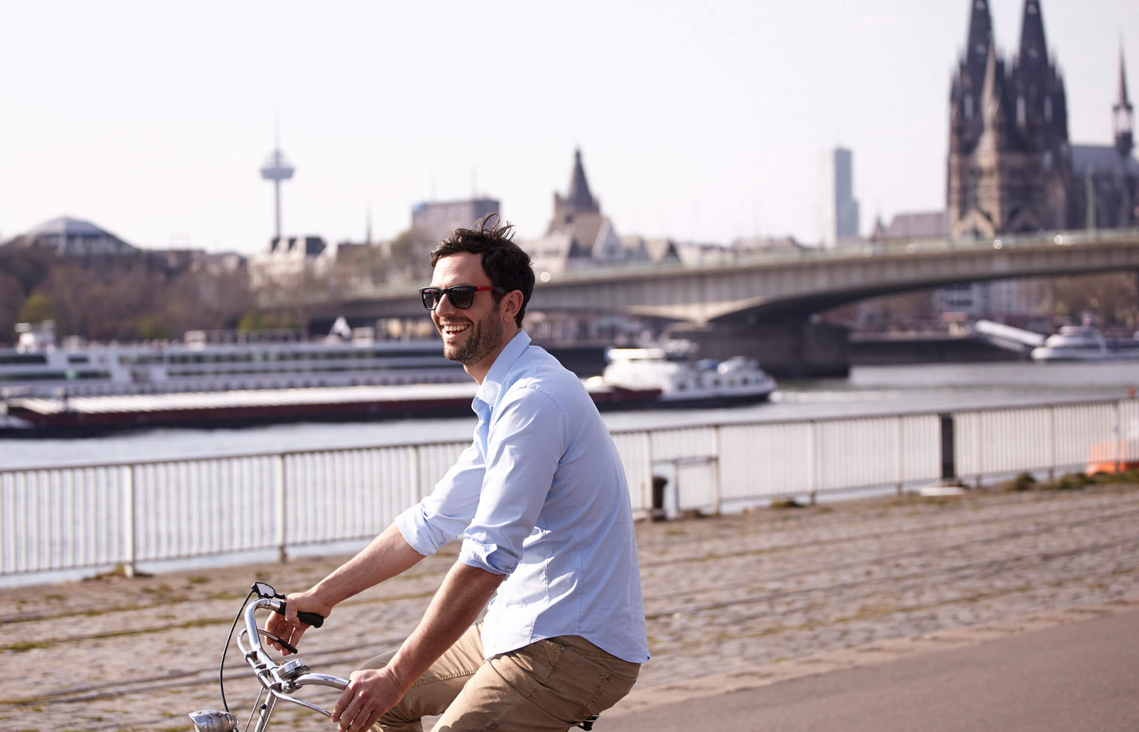 Mann auf Fahrrad am Rhein